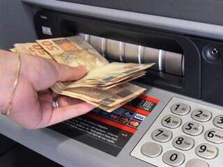 Servidor sacando dinheiro em caixa eletrônico (Foto: Divulgação/ Prefeitura)