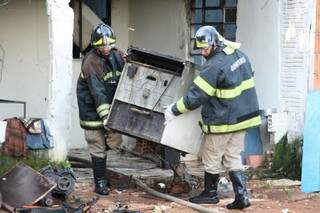 Bombeiros retiram móveis de casa atingida pelo fogo (Foto: Marcos Ermínio)