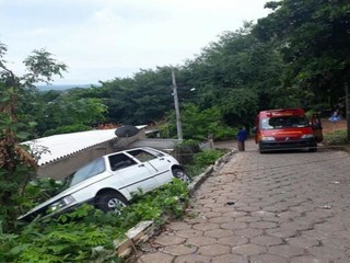 Carro sai da pista, fica pendurado e por pouco não cai sobre residência Carro sai da pista, fica pendurado e por pouco não cai sobre residência