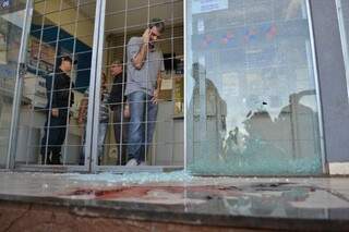 Tiros disparados por bandido destruíram vidro da entrada da lotérica (Foto: Cleber Gellio)