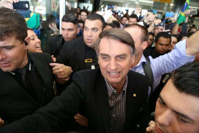 Bolsonaro chega e, nos ombros do filho, critica o PT e a corrup&ccedil;&atilde;o
