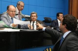 Na mesa, da direita para esquerda, os deputados Junior Mochi (MDB), George Takimoto (MDB), Onevan de Matos (PSDB) e Amarildo Cruz (PT); em pé e entregando documento durante sessão, o deputado Beto Pereira (PSDB) (Foto: ALMS/Arquivo)