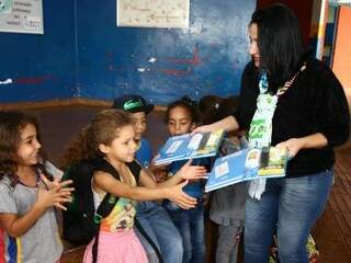 Secretária de Educação entrega cadernos a alunos de escola municipal (Foto: A. Frota/Divulgação)