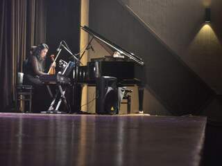No canto do palco, uma teclado, um violino e um piado de calda compunham o cenário também (Foto: Mariana Lopes)