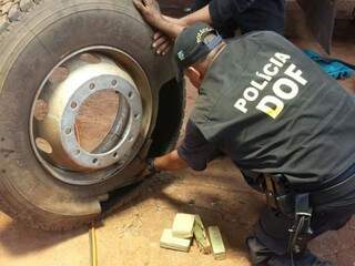 Policial retira tabletes de maconha de pneu de carreta (Foto: Divulgação)
