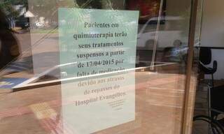 Direção da clínica que administra o Hospital do Câncer afixou comunicado aos pacientes sobre suspensão no atendimento (Foto: Eliel Oliveira)