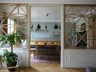Da sala para a cozinha, o gesso divide espaço com o painel de madeira vazado. 