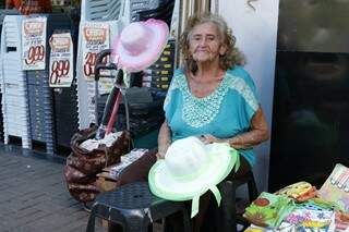 A idosa senta em seu banquinho e espera os clientes passarem para oferecer seus produtos (Foto: Kisie Ainoã)
