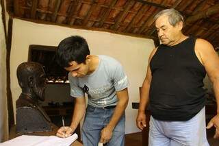Zaqueu e o filho, Everson, assinam a folha de vista do museu José Antônio. (Foto: Marcos Ermínio) 
