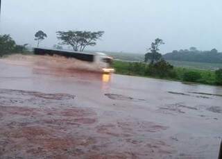 Caminhão teve dificuldade em atravessar a via coberta pela água. (Foto: Direto das Ruas)