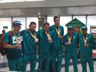Paratletas do futebol de 7 posam com a medalha de bronze no saguão do Aeroporto Internacional (Foto: Amanda Bogo)