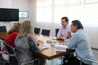 Prefeito Marquinhos Trad, vereador André Salineiro e representantes dos logistas durante reunião (Foto: Divulgação)