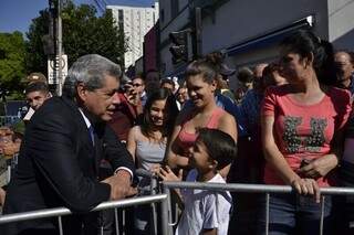 André conversando com um garoto ao chegar ao desfile na 14 de Julho (Foto: Cleber Gellio)