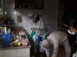 Agentes trabalhando na limpeza do imóvel vistoriado na manhã desta terça-feira (Foto: Divulgação/PMCG)