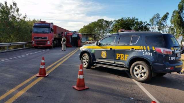 Carreta carregada com estacas de madeira tomba sobre ponte na BR-163