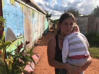 Ana Paula com um dos filhos no colo relata a situação dos moradores. (Foto: Liniker Ribeiro).