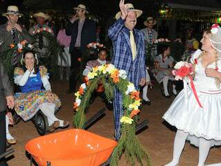 O prefeito de Dourados, Murilo Zauith, de terno azul, ao lado da noiva e do carrinho em que chegou a carregá-la. (Foto: Divulgação)
