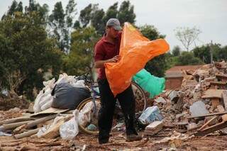Homem cata materiais recicláveis no meio de lixão de entulho (Foto: Marcos Ermínio)