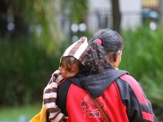 Colo de mãe é aconchego de criança em sexta fria na Capital. (Foto: André Bittar)