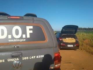 Viatura do DOF ao lado do veículo recheado de maconha. (Foto: Dourados News) 