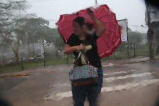 Moradora precisou segurar forte o guarda chuva diante dos ventos de até 74 km/h (Foto: Marcos Ermínio)