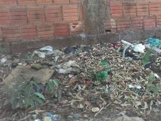 Garrafas, restos de roupas e folhas forram a calçada (Foto: Direto das ruas)
