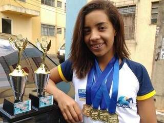 Gabriela posa ao lado de troféus e medalhas conquistadas desde os nove anos de idade (Foto: Arquivo Pessoal)