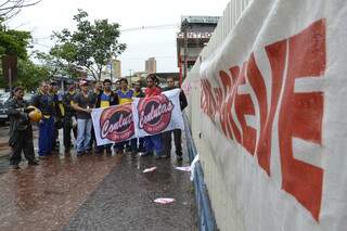 Sob chuva, funcionários fazem mobilização em frente ao prédio dos Correios. (Foto: Minamar Júnior)