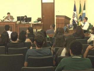 
Márcio sentado em frente ao juiz Rodrigo na sessão de julgamento. (Foto: Reprodução/TVC)