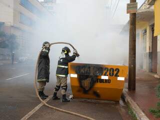 Bombeiros combatem incêndio em caçamba. (Foto: Simão Nogueira)