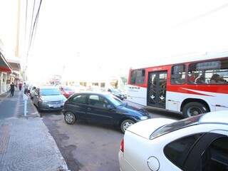 Motorista que tem dificuldade para achar vagas no Centro acabam atrapalhando o trânsito; enquanto um veículo sai, o outro aguarda a vaga na fila dupla (Foto: André Bittar)