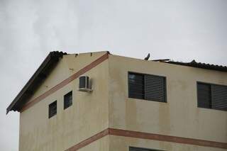 Com as telhas levadas pelo vento, buraco foi aberto em um dos blocos do residencial Leonel Brizola (Foto: Marcos Ermínio)