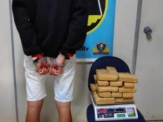 Jovem preso na delegacia ao lado dos tabletes de droga que estava traficando. (Foto: Divulgação) 