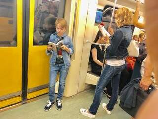 O menino e a mãe, ambos lendo livros no metrô de Moscou, onde a predominância é pela atenção ao celular (Foto: Paulo Nonato de Souza)