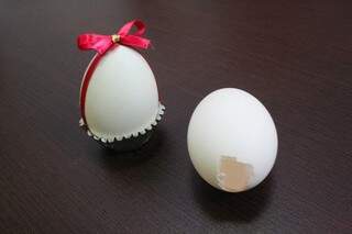 Sugestão de como enfeitar o ovo depois de pronto, simples, com forminha de doce e fita.
