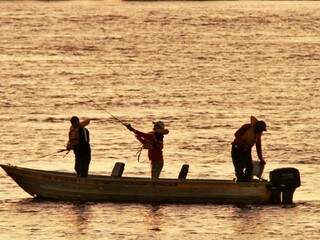 Por do sol começa a esconder as figuras dos pescadores no Rio Paraguai (Foto: Saul Schramm/Imasul)
