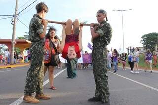 De cabeça para baixo e alçada por outros dois jovens vestidos de militares, trio representava o pau de arara. (Foto: Kísie Ainoã)