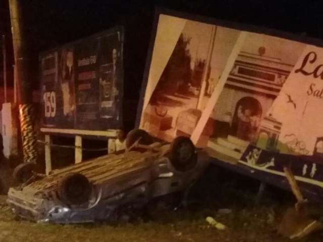Carro capota, bate em outdoor e tr&ecirc;s pessoas ficam feridas 