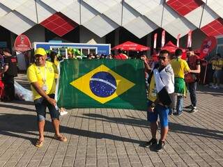 Flávio Rodrigues Farias, à esquerda, e o amigo Rogério Martins, com a bandeira brasileira em frente ao estádio em Moscou (Foto: Paulo Nonato de Souza)