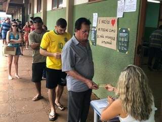 Eleitores fazem fila para votar em escola pública de Dourados (Foto: Carol Oliveira/RIT TV)
