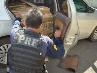 PRF retirando tabletes de maconha que estavam escondidos no interior de carro estacionado em hotel (Foto: PRF/Assessoria