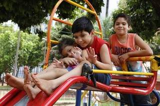 Os primos Emilly, Mateus e Michel se divertem no escarregador na Praça Ari Coelho. (Foto:Gerson Walber)