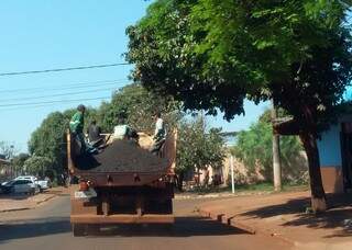 Trabalhadores que fazem tapa-buraco são transportados em carroceria, em meio ao material usado para consertar ruas (Foto: Divulgação)