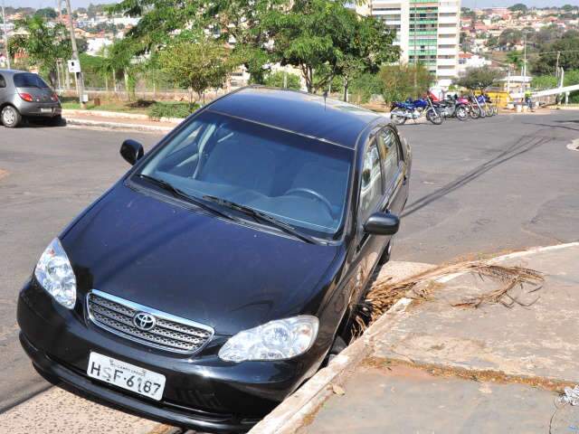  Corolla fica "atolado" em boca-de-lobo que virou armadilha no bairro Santa F&eacute;