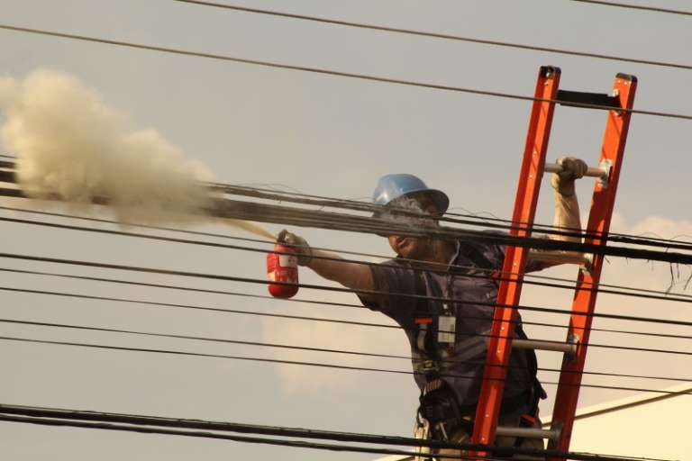 Funcionário usa extintor para apagar fogo (Foto: Marcos Erminio)