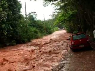 Imagem capturada por moradora mostra estrada na Chácara dos Poderes tomada por enxurrada. (Foto: Direto das Ruas)