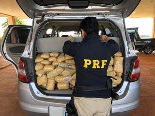 Policiais rodoviário federal com droga apreendida em veículo Spin (Foto: Assessoria/ PRF)