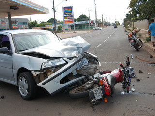 Moto para embaixo de carro após acidente provocado por conversão à esquerda. (Foto: Simão Nogueira)