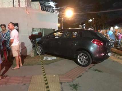 Após colisão em cruzamento, carro invade calçada e destrói muro de casa 