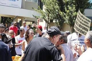 Assessor de deputado (à direita, conversando com homem de boné) foi hostilizado por manifestantes (Foto: Helio de Freitas)